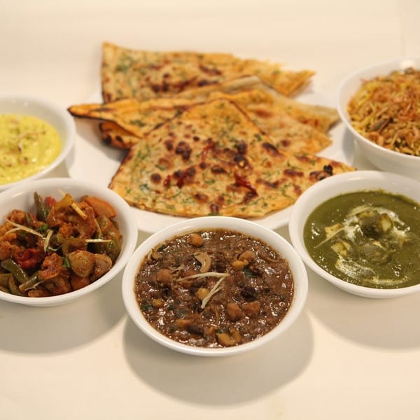 A spread of Indian dishes including naan, curries, and rice, from CURRY ZONE.