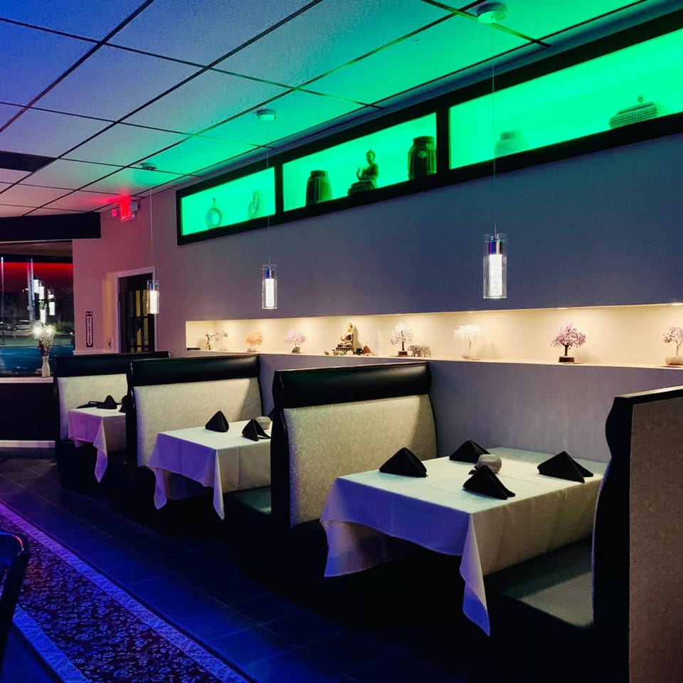 The CURRY ZONE dining room features booths, white tablecloths, and green accent lighting with decorative objects.